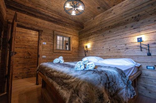 1 dormitorio con 1 cama en una cabaña de madera en Casa Aquila, en Cortina dʼAmpezzo