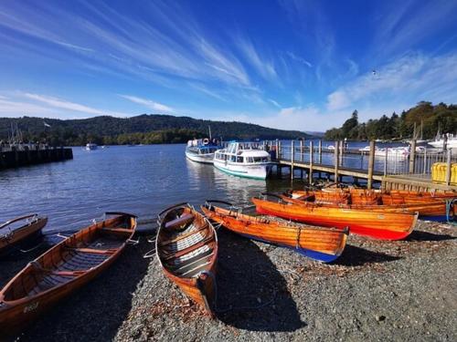 a group of boats sitting on the shore of a lake at 1 West End Boutique Apartment in Bowness-on-Windermere