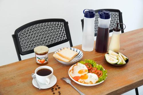 a table with a plate of eggs and bread and coffee at CT HomeStay Da Nang in Danang