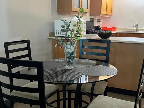 a table with chairs and a vase with flowers on it at Splendid Inn in Florence Hall