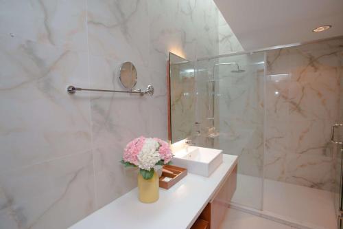 a bathroom with a sink and a vase of flowers at Bạch Yến T111-Happy Villa Đại Lải Resort in Vĩnh Phúc