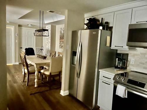a kitchen with a refrigerator and a table with chairs at On top of the world at Sugar Top Resort in Sugar Mountain