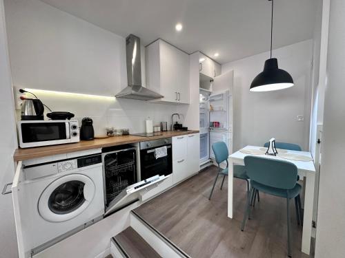 马德里Loft Moderno en Madrid的厨房配有洗衣机和桌椅