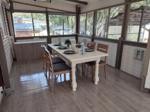 a dining room with a white table and chairs at Mobil-home climatisé 6 pers en Ardèche in Orgnac-lʼAven
