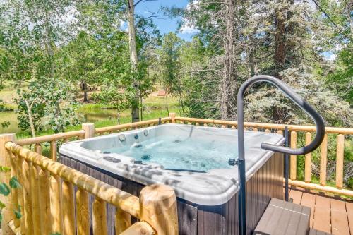 a jacuzzi tub on a deck with trees at Private Hot Tub and Pond Conifer Log Cabin in Conifer