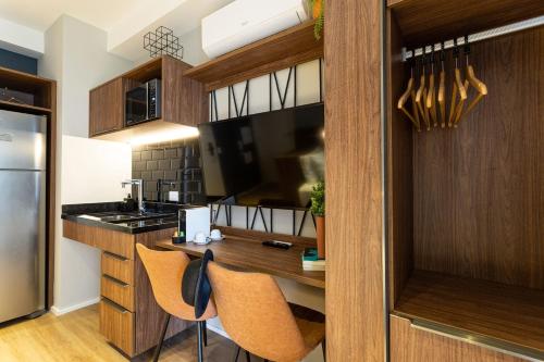 a kitchen with wooden cabinets and a counter with chairs at Charlie Hotel Atmosfera Paulista in Sao Paulo