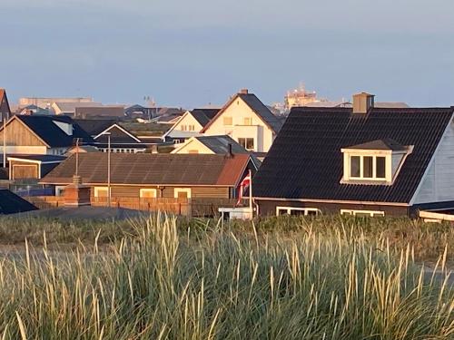 a group of houses with roofs on a field at 200 m til havet - fri adgang til svømmehal in Thyborøn