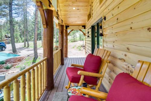 a porch of a cabin with two chairs at Private Hot Tub and Pond Conifer Log Cabin in Conifer