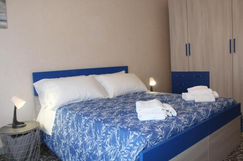 a bedroom with a blue bed with towels on it at Abate Gimma Apartment in Bari