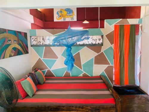 een kamer met een bank en een kleurrijke muur bij Ramya Ru Beach Home in Galle