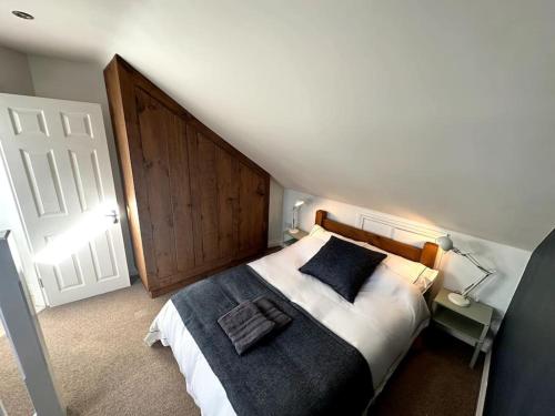 a bedroom with a large bed with a wooden headboard at Cosy & quirky cottage in the heart of Bakewell. in Bakewell
