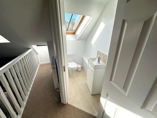 een zolderbadkamer met een toilet en een raam bij Cosy & quirky cottage in the heart of Bakewell. in Bakewell