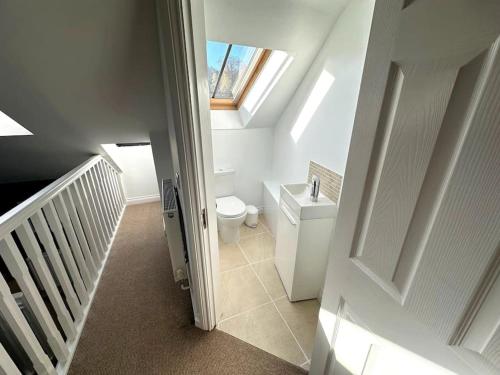 an attic bathroom with a toilet and a window at Cosy & quirky cottage in the heart of Bakewell. in Bakewell