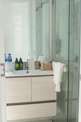 a bathroom with a shower and a sink with a mirror at Karibao Resort Town in Playas