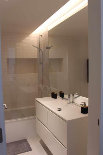 a white bathroom with a sink and a shower at Seaside Fort House, T2 Tavira – Cabanas de Tavira in Cabanas de Tavira