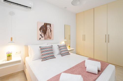 um quarto branco com uma cama grande e armários brancos em K&D Central Suite em Sitia