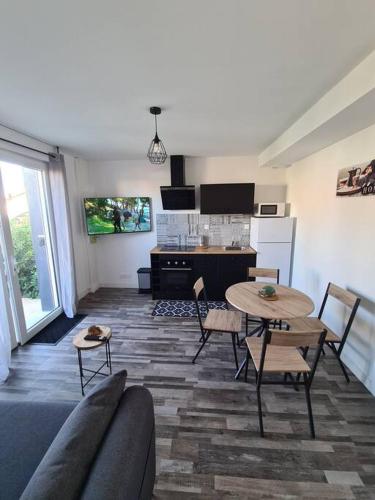 un salon avec une table et une cuisine dans l'établissement Le Petit Hérisson joli logement au rez-de-jardin à Les Herbiers, aux Herbiers