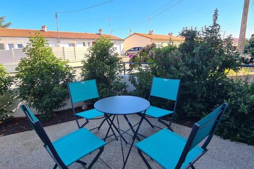 une table et quatre chaises assises autour d'une table et de chaises dans l'établissement Le Petit Hérisson joli logement au rez-de-jardin à Les Herbiers, aux Herbiers