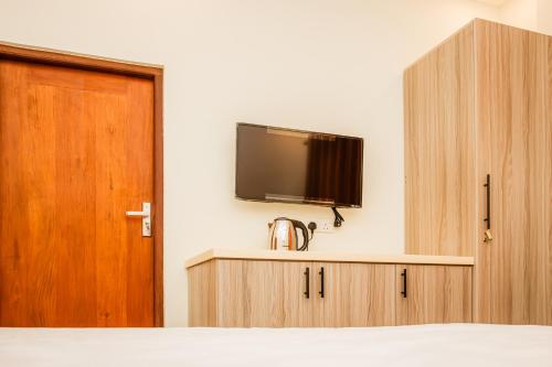 a bedroom with a tv on the wall and a bed at ANILAD Kandy in Kandy