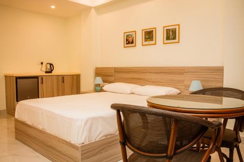 a bedroom with a bed and a table and chairs at ANILAD Kandy in Kandy