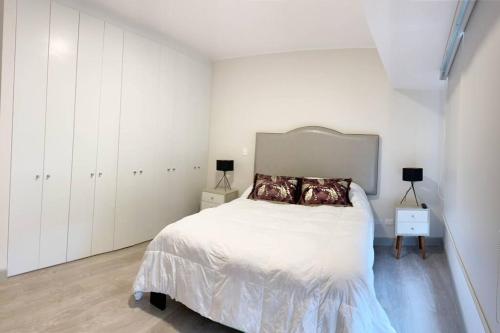 a white bedroom with a bed and white cabinets at MLA apartments - Reducto 360 in Lima