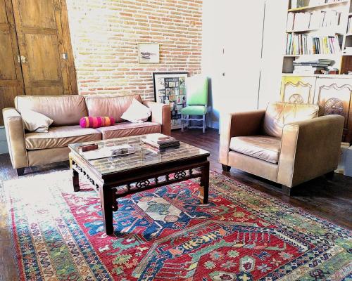 a living room with two couches and a coffee table at Gîte Comme une parenthèse in Moissac