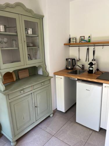 eine Küche mit einem grünen Schrank und einem Waschbecken in der Unterkunft Teichland Linum Apartments in Fehrbellin