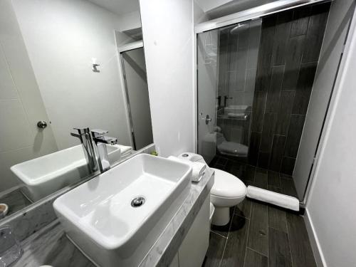 a white bathroom with a sink and a toilet at MLA apartments - Reducto 360 in Lima