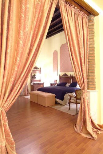 a bedroom with a bed with curtains in it at Hotel Palacio de Oñate in Guadix