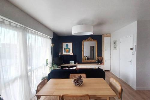 ein Wohnzimmer mit einem Tisch und einem Sofa in der Unterkunft Magnifique T2 à Bordeaux in Bordeaux