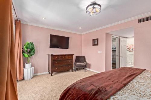 a bedroom with a bed and a tv on a wall at Resort Style Living In Phoenix's Most Exclusive Gated Community! in Phoenix