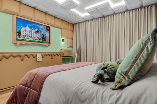 um quarto com uma cama com um elefante deitado sobre ela em Chocoland Hotel Gramado soft opening em Gramado