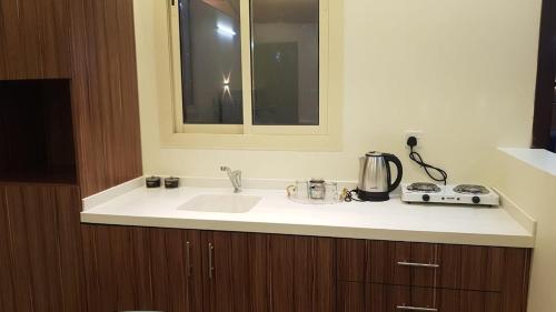 a kitchen counter with a sink and a mirror at شاليهات التميز الراقي in Al Hada