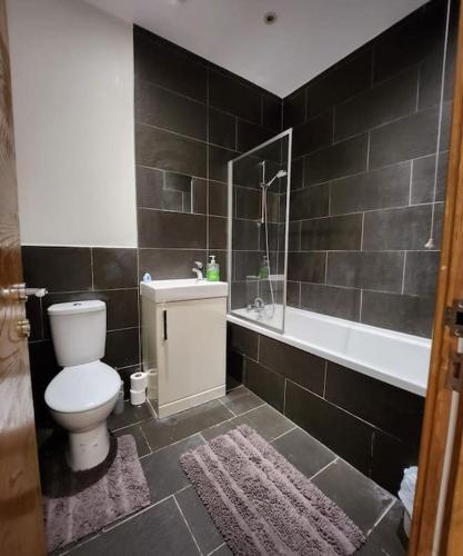 a bathroom with a toilet and a sink and a tub at Imperial House Sea View Margate in Kent