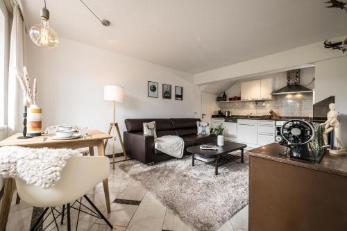 una sala de estar con un sofá y una mesa en VIEW4TWO / Chalet-Apartment Zillertal, en Hart im Zillertal
