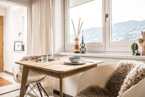 a dining room with a table and chairs and a window at VIEW4TWO / Chalet-Apartment Zillertal in Hart im Zillertal