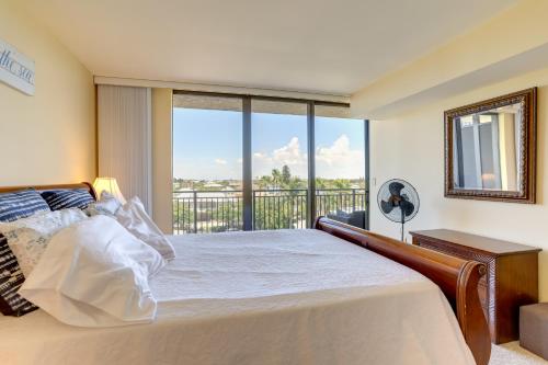 a bedroom with a large bed and a balcony at Treasure Island Resort Condo with Beach Access! in St Pete Beach