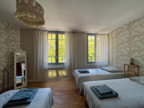 - une chambre avec 3 lits et 2 fenêtres dans l'établissement Le gîte du port canal, à Moissac