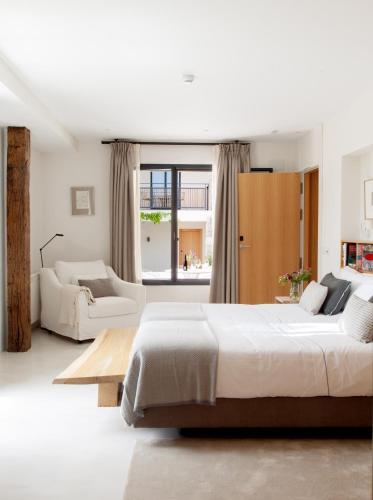 a white bedroom with a large bed and a couch at Quinta San Francisco in Castrojeriz