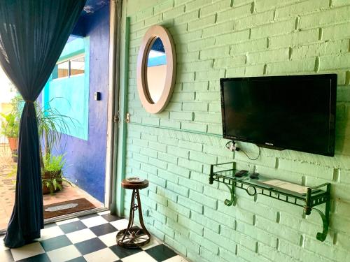 a flat screen tv hanging on a brick wall at Unique Studio Beach RG4 in Puerto Vallarta