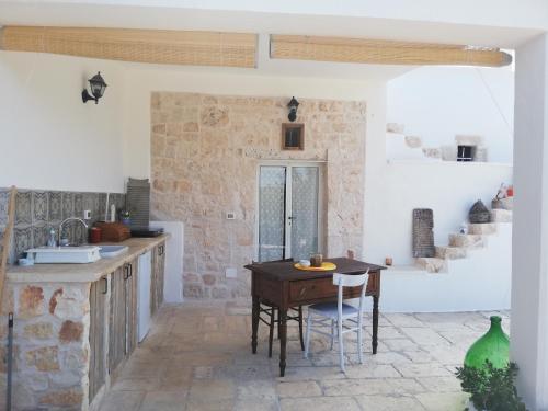 a kitchen with a wooden table in a room at Holiday Home Trullo Antico in Ostuni