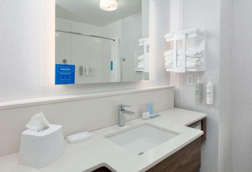 a white bathroom with a sink and a mirror at Hampton Inn Norfolk in Norfolk