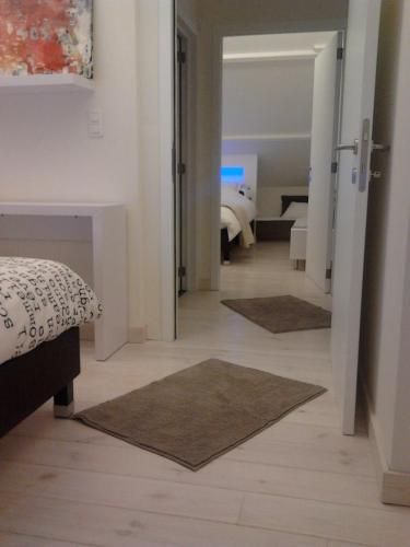 a bedroom with a bed and a hallway with rugs at A L'inattendue in Bertrix