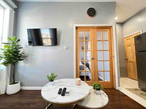 a living room with a table and a tv on the wall at Stylish 1 Bedroom Apt - Brooklyn by train station in Brooklyn