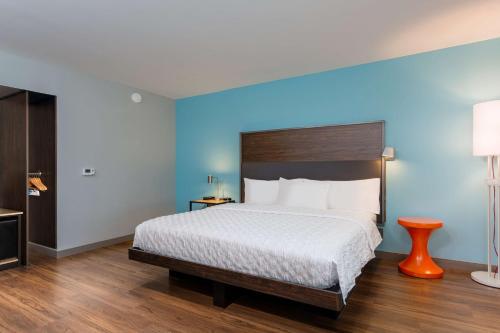 1 dormitorio con 1 cama grande y pared azul en Tru By Hilton Ashland, Va en Ashland