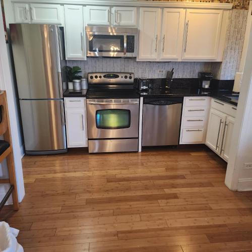 a kitchen with white cabinets and stainless steel appliances at Cozy View Downtown Atlanta Condo in Atlanta