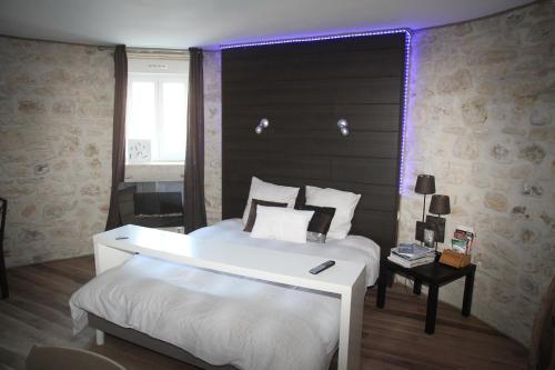 a bedroom with a white bed and a purple light at Gîte Lorengrain in Bruyères-et-Montbérault