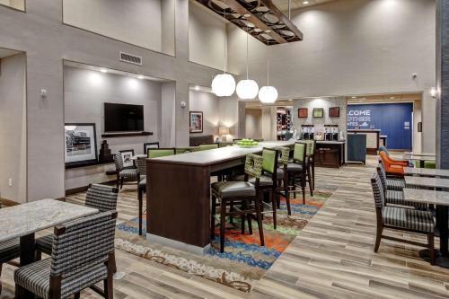 a restaurant with a long bar with chairs and tables at Hampton Inn & Suites Culpeper in Culpeper