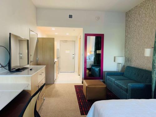 a hotel room with a bed and a couch at Home2 Suites By Hilton Edinburg in Edinburg