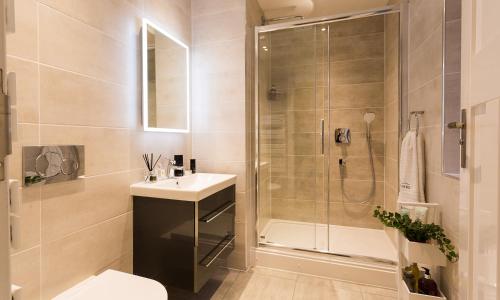 a bathroom with a shower and a sink and a toilet at Mulberry At Applethwaite Hall in Windermere